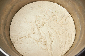 Mixing dough with professional kneader machine at the manufacturing. Equipment for making flour products