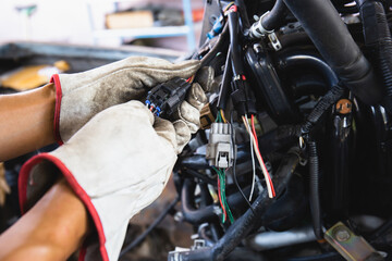 Close up hands of auto mechanic doing car service and maintenance. Car wiring with adapters and...