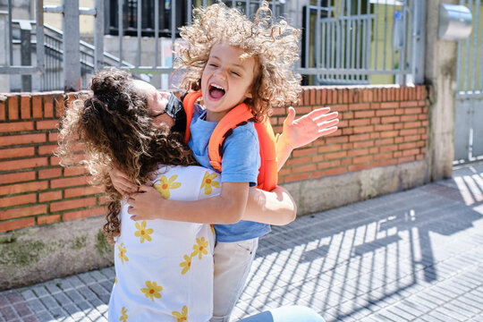 Latin Child Hugs His Mother At The School Exit