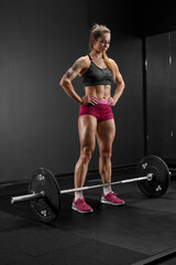 Fototapeta na wymiar Muscular woman doing crossfit exercise with barbell. Athletic girl working out in gym