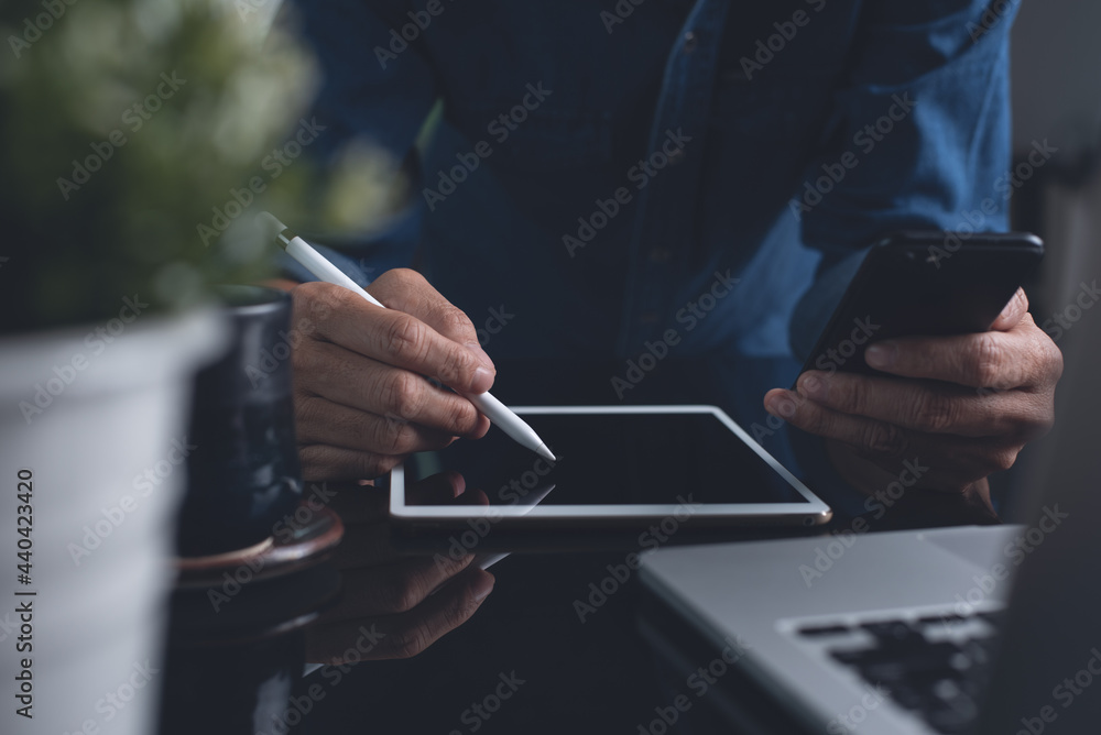 Aufkleber man man using mobile phone, and stylus pen on digital tablet during working on laptop computer from 