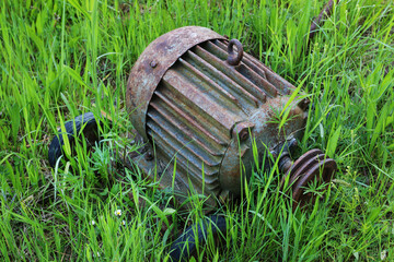 Fototapeta premium An antique electric motor lying on the grass.