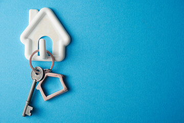 High angle view of keyring with a small house on colored background