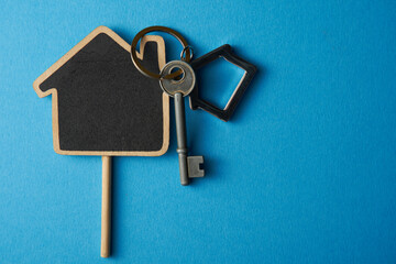 High angle view of keyring with a small house on colored background