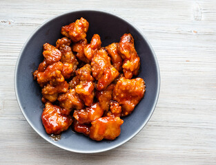 chinese cuisine - top view of sweet and sour pork (guo bao rou) in gray bowl on wooden table