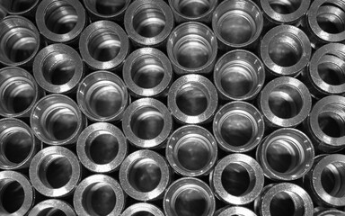 Background from many metal pipes packed in rows. Lots of internally threaded pipes. Plumbing equipment. View from above.