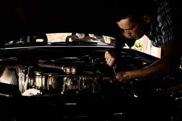 a man repairing a car engine under the hood