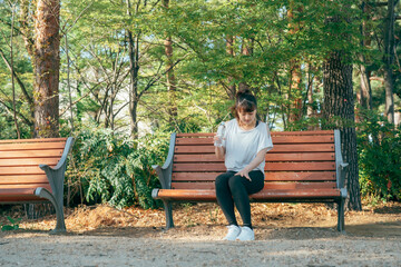 トレーニング中に休憩する女性（膝・足が痛い）
