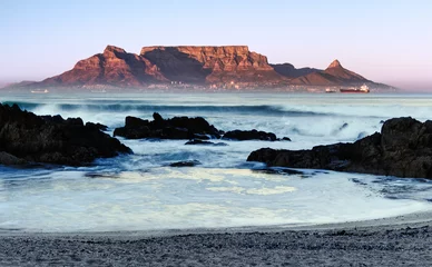 Foto auf Acrylglas Tafelberg The mid winter sunrise lights up the front of Table Mountain as viewed from Bloubergstrand in Cape Town, South Africa.