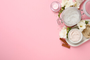 Flat lay composition with body scrubs on pink background, space for text