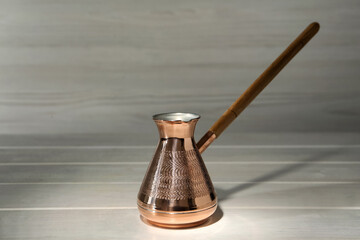 Obraz na płótnie Canvas Beautiful copper turkish coffee pot on white wooden table