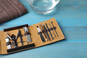 Manicure set in case on light blue wooden background