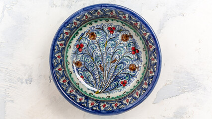 Ethnic Uzbek ceramic dish with white floral ornament in Central Asian style. Decorative ceramic with traditional uzbekistan ornament on a white background