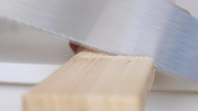 Man sawing wooden plank with hand manual saw. Closeup