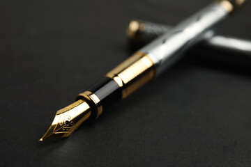 Beautiful fountain pen with ornate nib on black table, closeup
