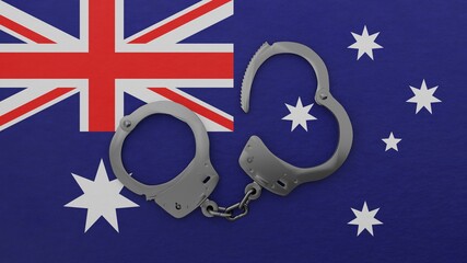 A half opened steel handcuff in center on top of the national flag of Australia