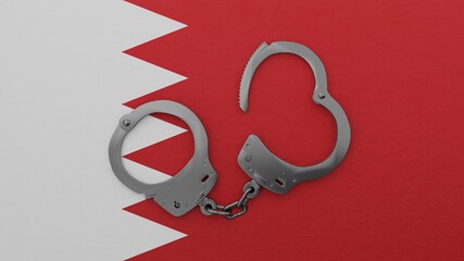 A half opened steel handcuff in center on top of the national flag of Bahrain