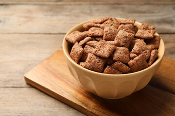 Sweet crispy corn pads in bowl on wooden table