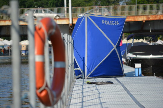 Policyjny parawan na marinie miejskiej zasłania zwłoki.