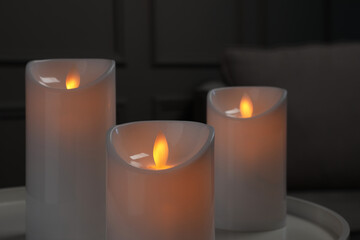 Fototapeta na wymiar Decorative LED candles on white table indoors