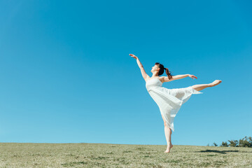 空と白いワンピースの踊る女性（アラベスク）

