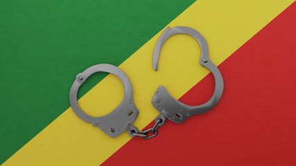 A half opened steel handcuff in center on top of the national flag of Republic of the Congo
