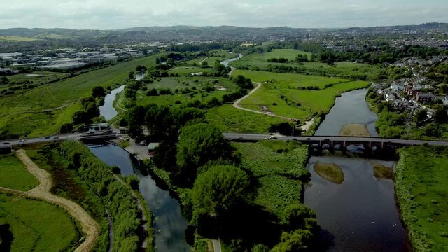 Flying over the Exeter shipping canal and the river Exe towards countess wear bridge and swing bridge in summer