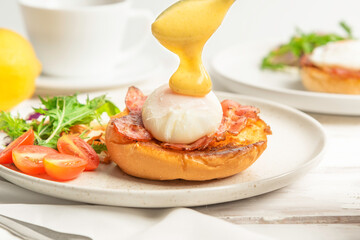 Eggs Benedict with hollandaise sauce on toast with bacon,breakfast 