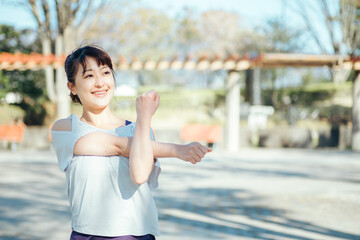 公園で準備運動する女性（腕）
