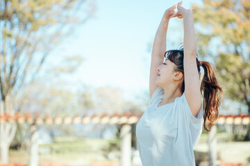 公園でスポーツしながら深呼吸する女性
