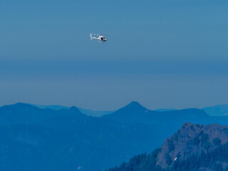 Fototapeta na wymiar Helicopter flying above mountains