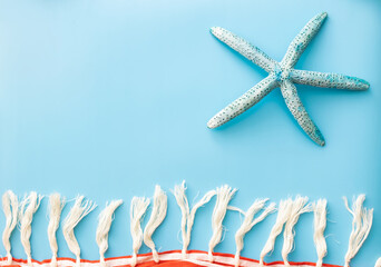 summer background of pareos with fringe and starfish on blue backdrop