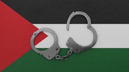 A half opened steel handcuff in center on top of the national flag of Palestine