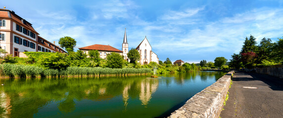 Fototapeta na wymiar Pond with view of the Catholic Parish Church and castle in Hammelburg- Bavaria