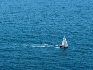 A sailboat sails the Mediterranean near the Nao Cape in Javea, Spain