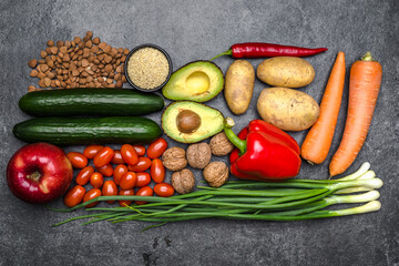 Healthy food background. Healthy vegetarian food. Vegetables and fruits on black stone. Clean vegetarian eating concept.