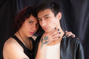 The transgender homosexual young male couple together in closeup portrait facing camera in studio 