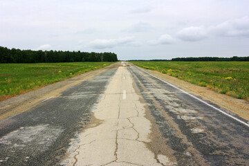 Empty asphalt road in green field