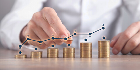 Man stacking coins with a graph of profit.
