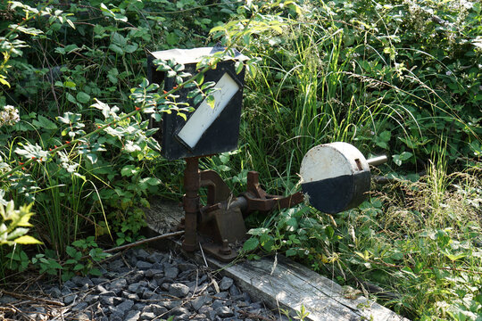 Weathered And Abandoned Railroad Switch Control Stand On Background Of Plants