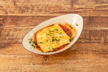 nice bowl with Italian lasagna stuffed with beef with lots of parsley and lots of pomodoro sauce