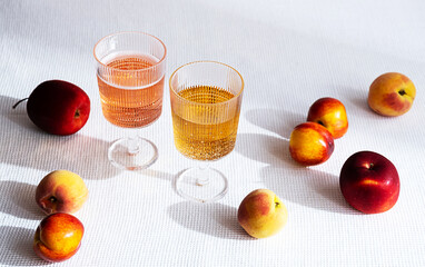 Summer modern still life, various fruits and two wine glass with long shadows.