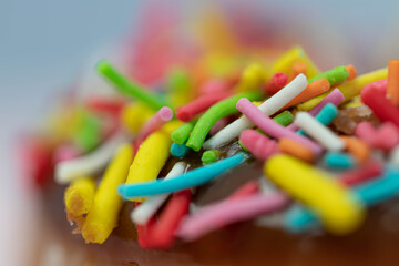 Obraz premium Pastries concept. Donuts with chocolate glaze with colorfull sprinkles, on a pink plate. Macro