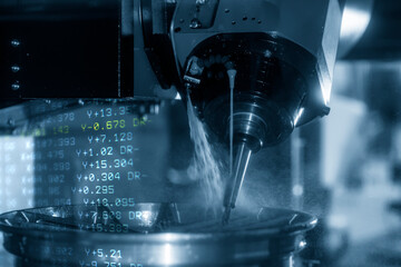 The abstract scene 5-axis  machining center cutting the magnesium alloy wheel parts with G-code data back ground. The hi-precision automotive manufacturing process by multi-axis CNC milling machine.