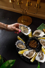 open fresh oysters on a metal plate in ice on a concrete background
