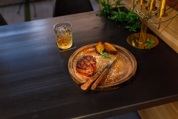 filet mignon medium rare served on a wooden plate with baked potatoes