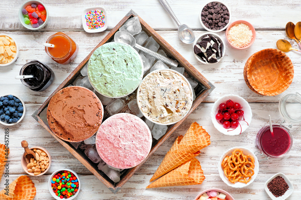 Poster summer ice cream buffet with a variety of ice cream flavors and sweet toppings. overhead view table 