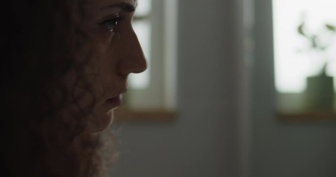 Close up of a beautiful woman staring at herself in the mirror. Slow motion, handheld.