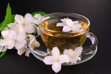 Fototapeta na wymiar Jasmine tea in a transparent cup on a black background.