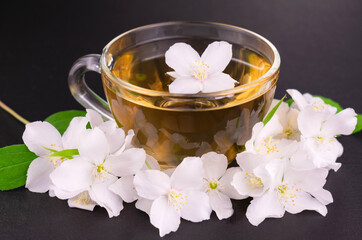 Obraz na płótnie Canvas Jasmine tea in a cup on a black background. Close-up.